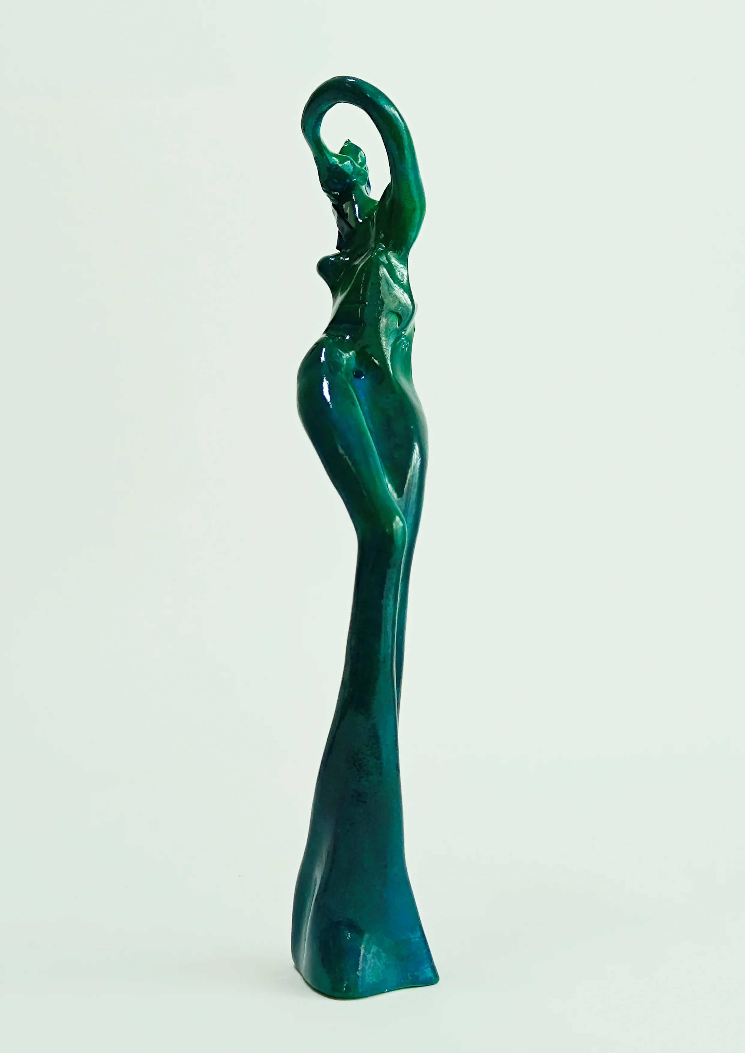 Figura en pie con una mano en el cuello. Tonos verdes. 31x6x9 centímetros. 370 gramos